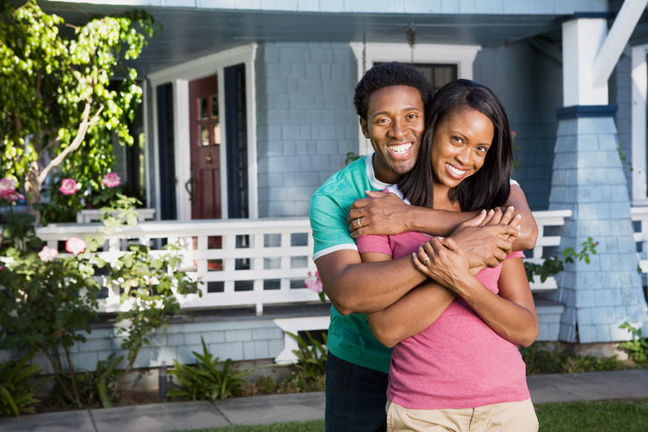 A sweet couple in front of their house.