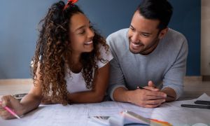 Couple laying on floor discussing plans